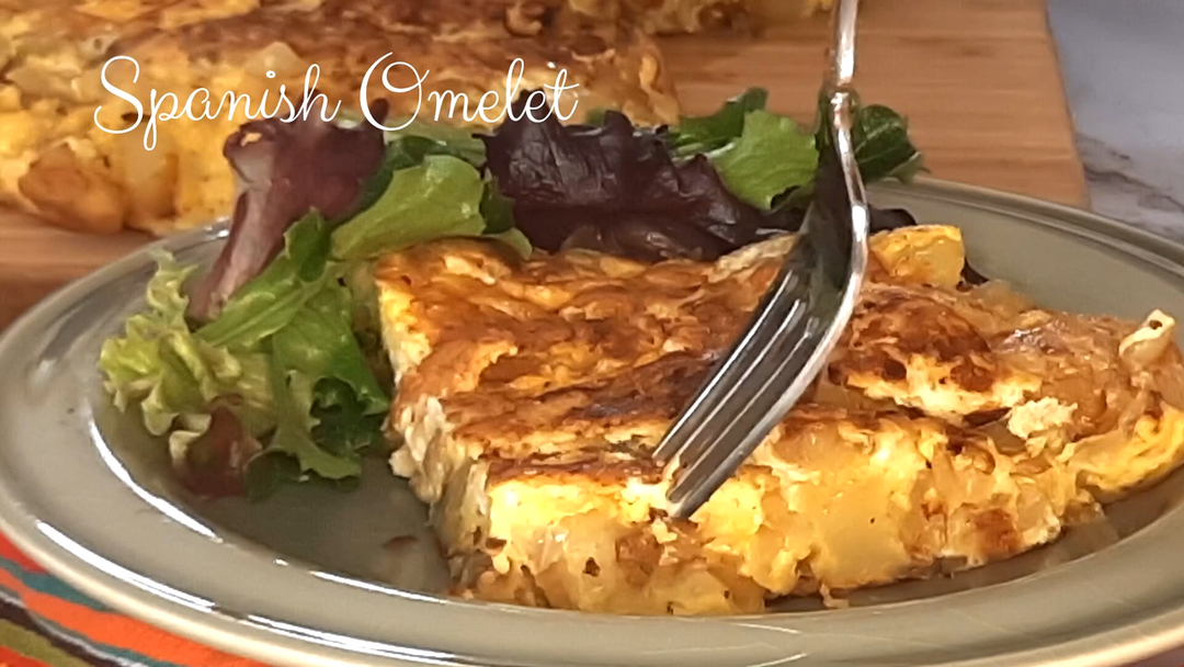 Spanish omelet on a plate with salad and a fork, labeled 'Spanish Omelet'.